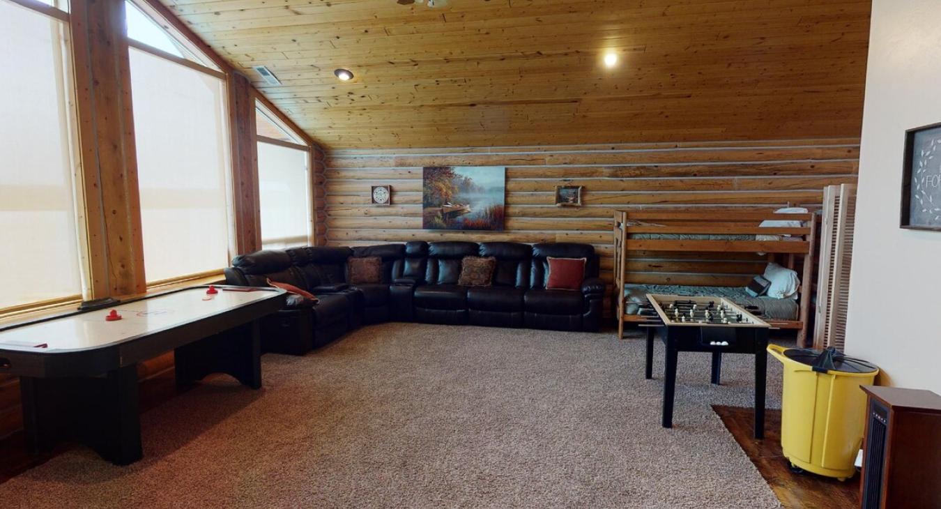 Upstairs loft is equipped with sectional couch, satellite tv, and foosball table.