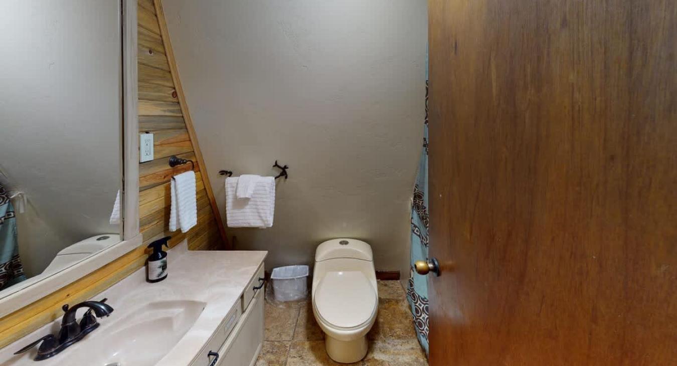 The main level has a full bathroom with a shower, toilet, and a sink vanity.