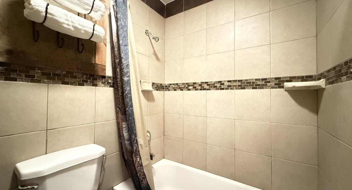 Main floor bathroom is equipped with a shower/tub, toilet, and sink vanity.