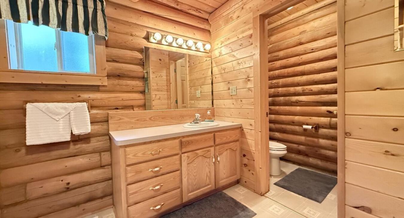 Main level bathroom with shower/tub, toilet, and sink.