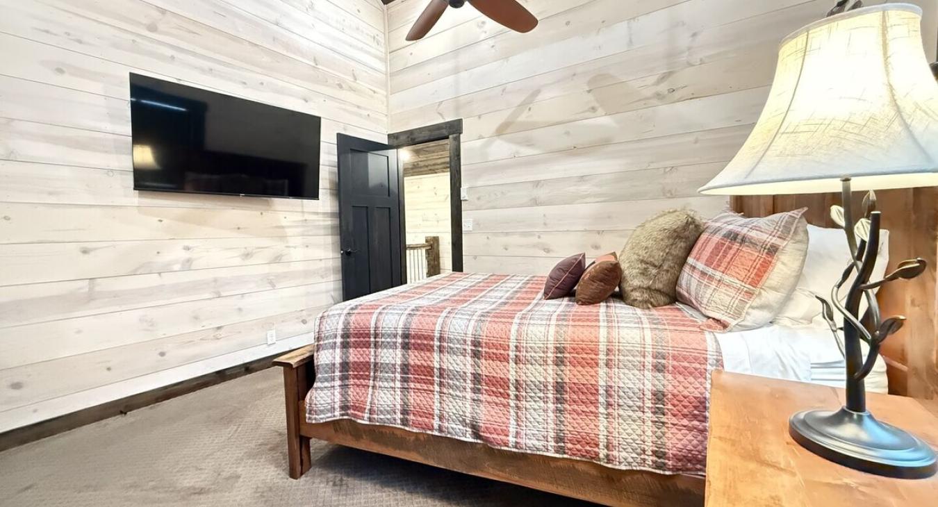 Queen bedroom with flat screen tv and walk in closet.