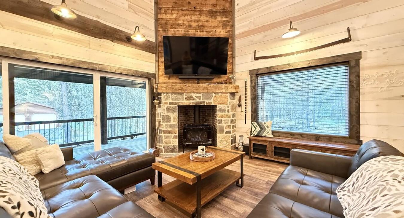 View of the living room smart tv and propane fireplace along with the beautiful views out the windows.