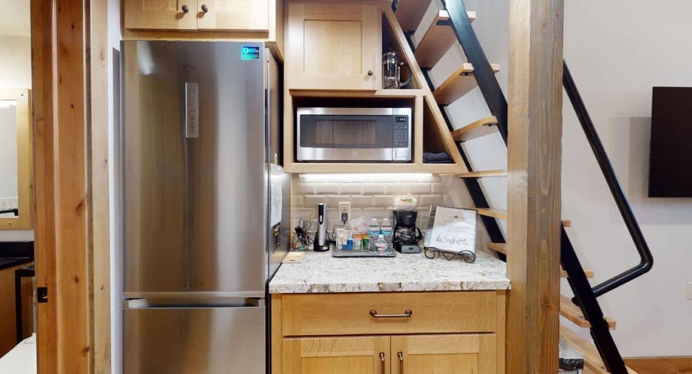 Other side of the kitchen highlighting other commodities such as a microwave, fridge, and coffee machine.