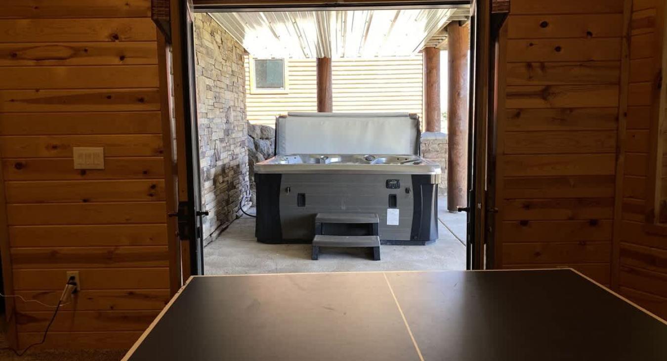 From the door of the game room you can access the large hot tub this cabin has to offer.