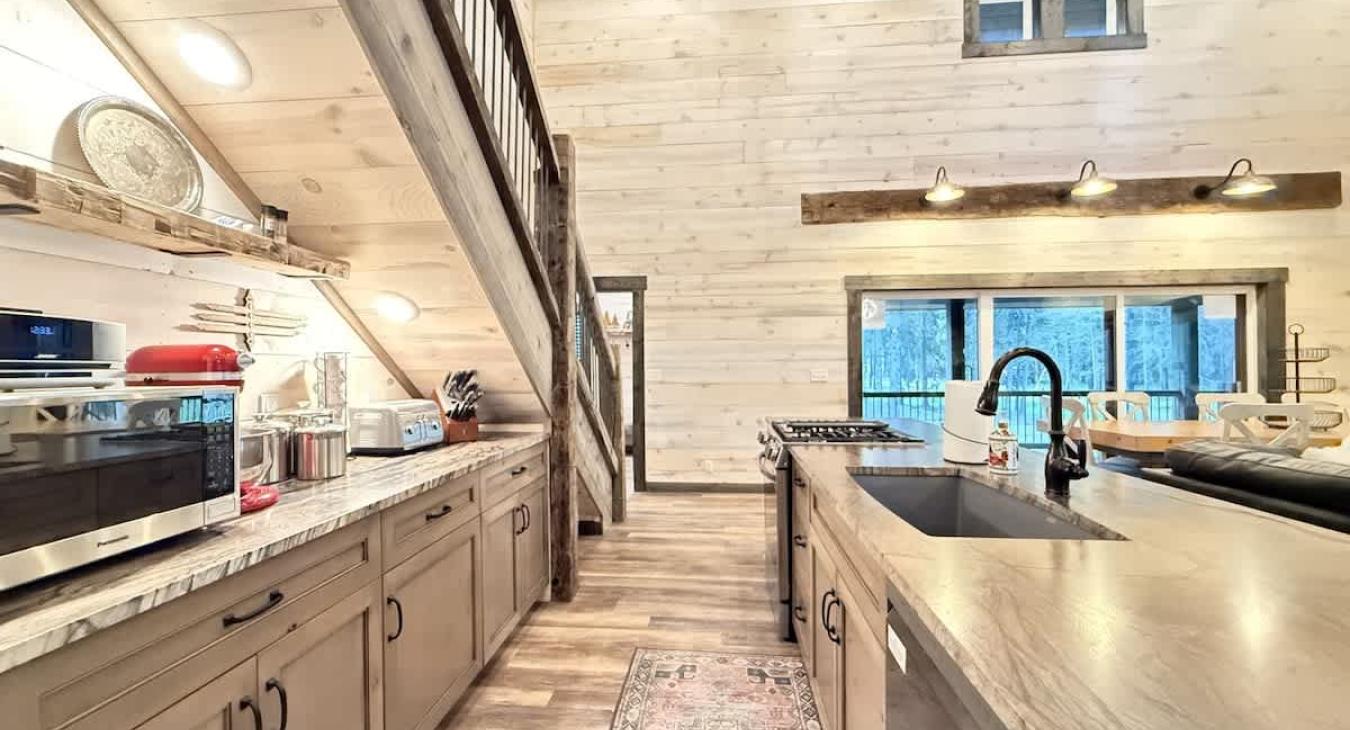 Very open kitchen with appliances, pots and pans, basic cooking essentials, dishes, and utensils.