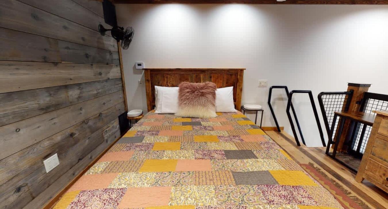 Queen sized bed comes equipped with clean linens and blankets.