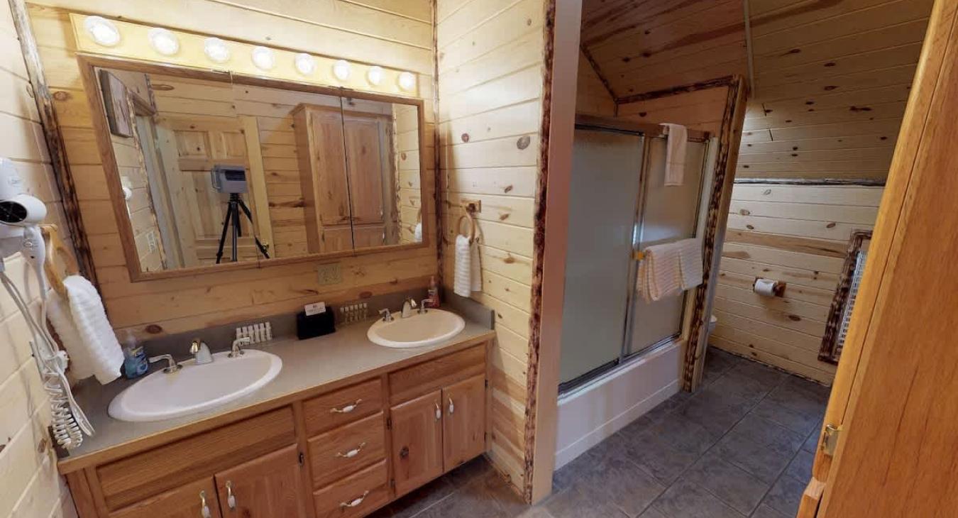 Shared bathroom located upstairs with a double sink vanity, toilet, and shower/tub combo.