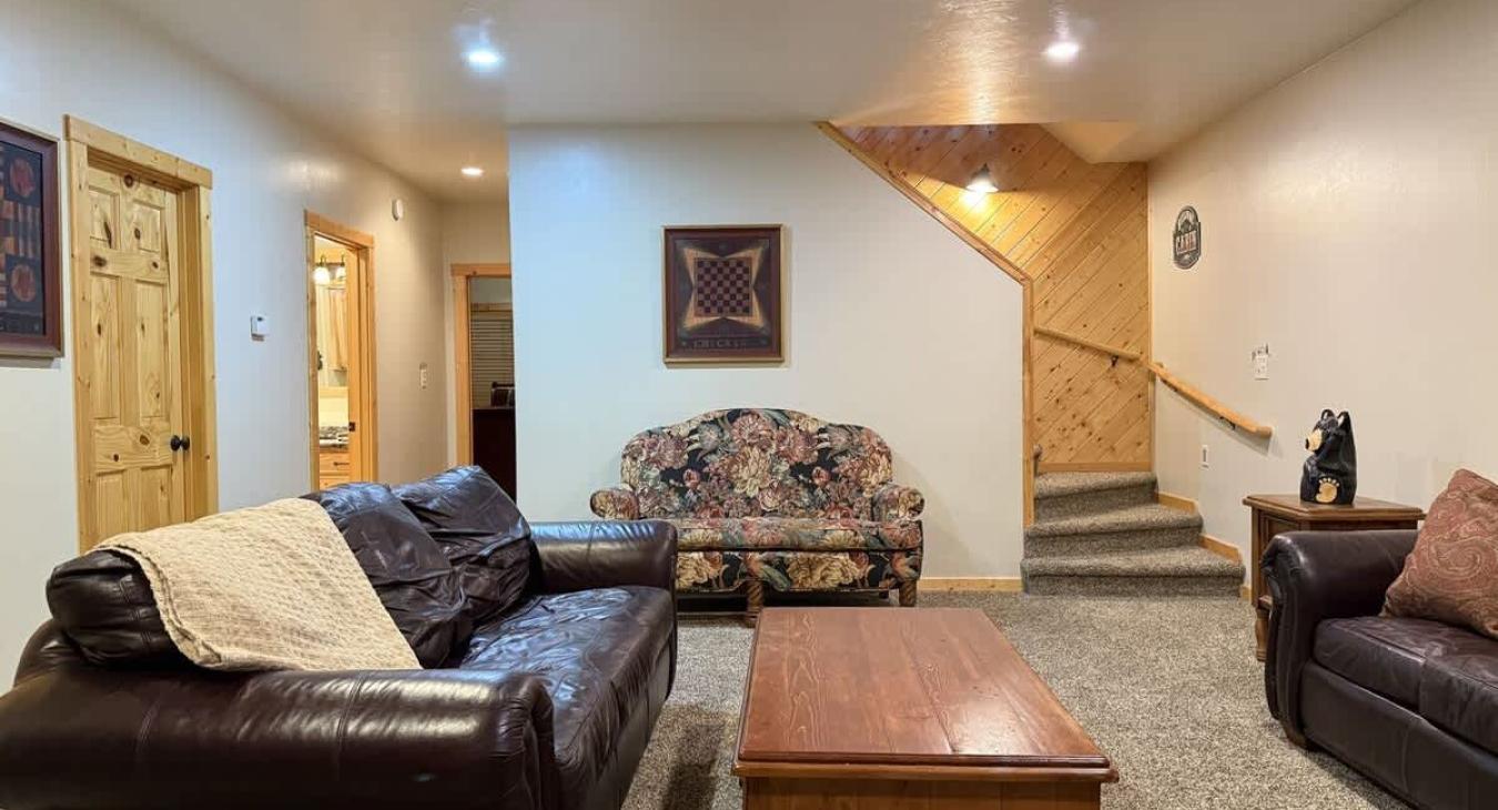 As you walk down the stairs, you're greeted by warm, ambient lighting and the gentle crackle of a fireplace.