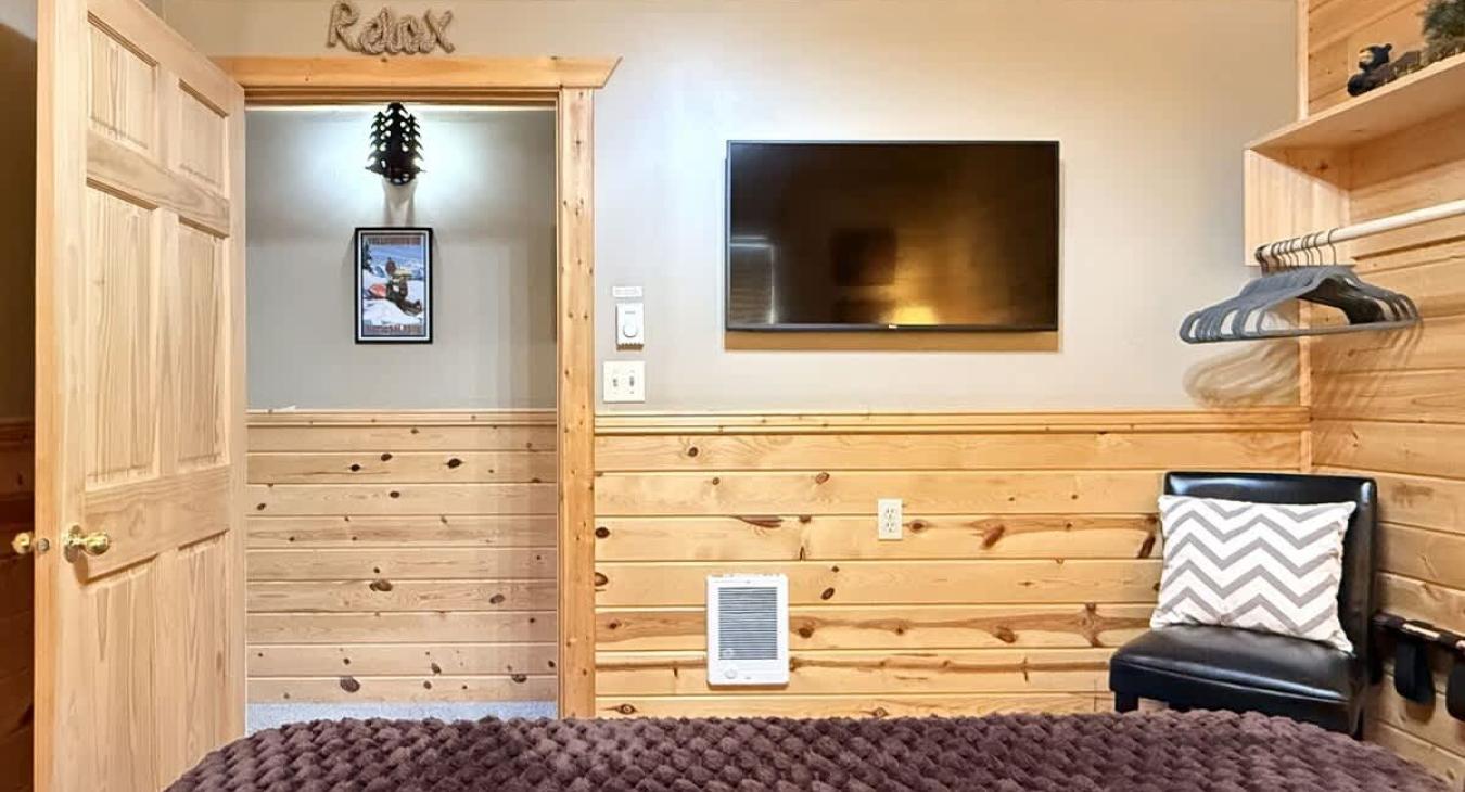 Across from the bed is a flat-screen TV—simple, unobtrusive, ready for late-night movies or quiet mornings.