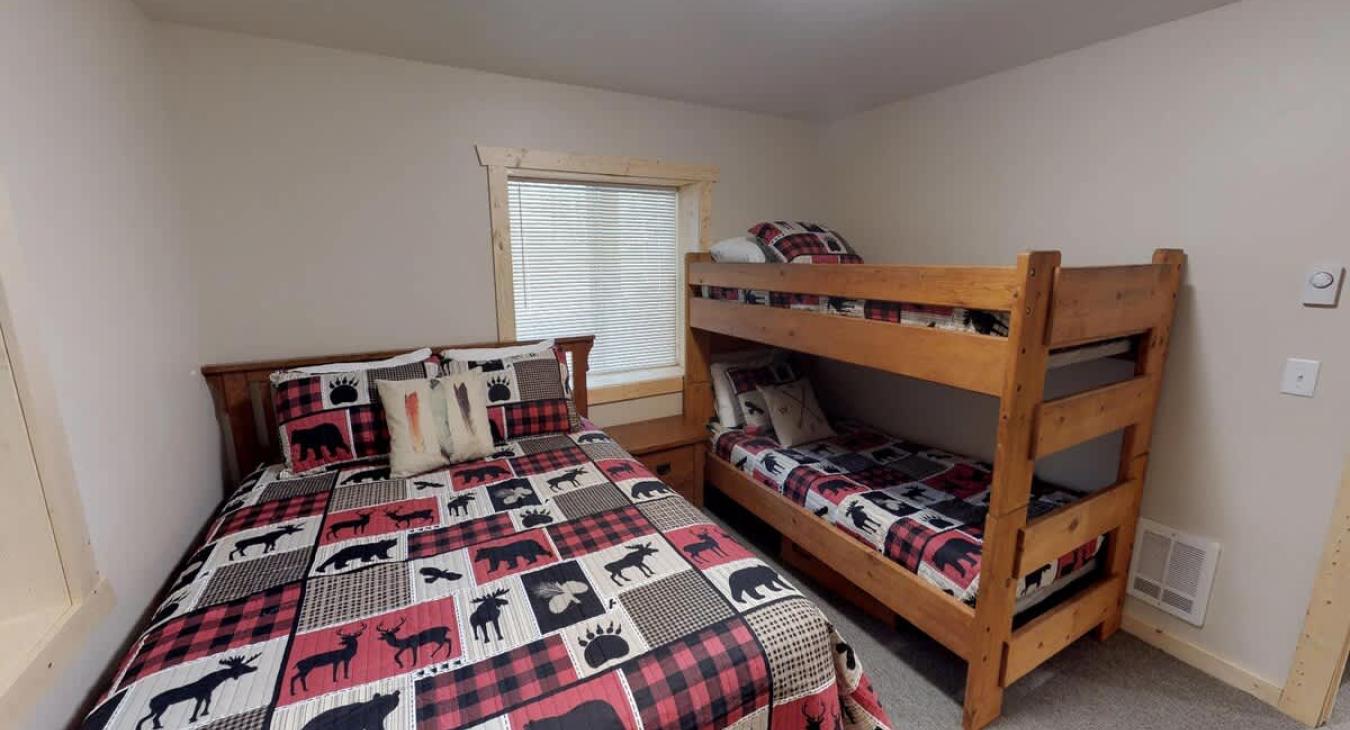 Bedroom #4 located in the basement with a Queen size bed and bunk bed.