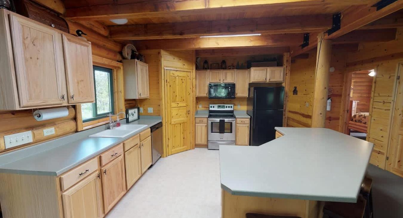 Large kitchen with appliances, cookware, dishes, and basic cooking essentials.