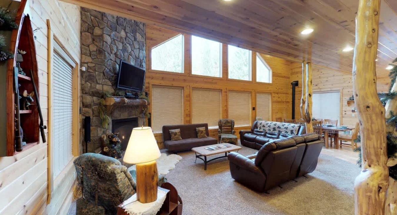 The living room has seating, a wood fireplace, and a television for entertainment. Wood is not provided be sure to bring your own.