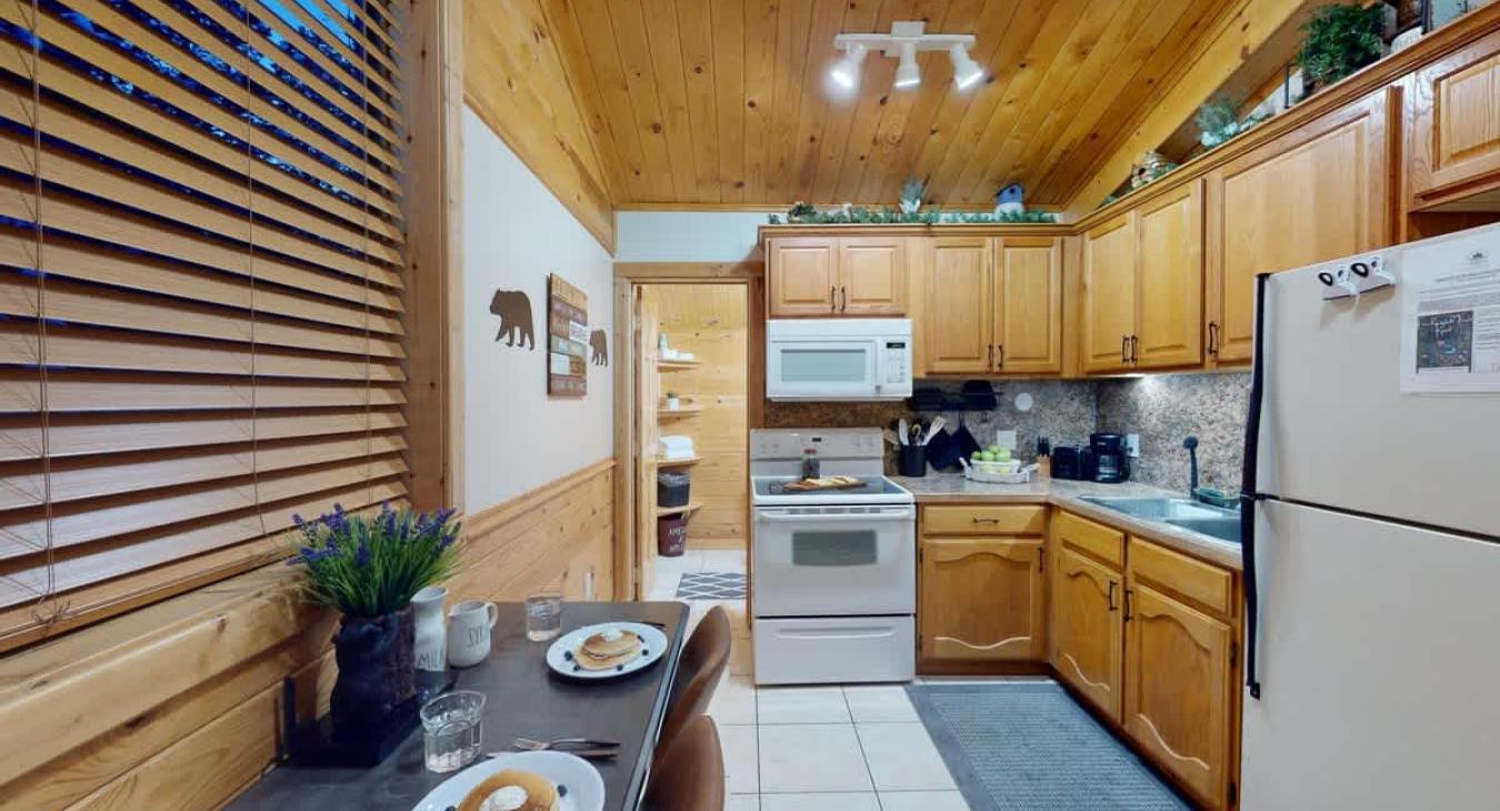 A full kitchen with appliances and dining table to enjoy.
