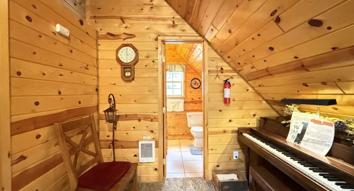Upstairs loft corner with piano and seating.