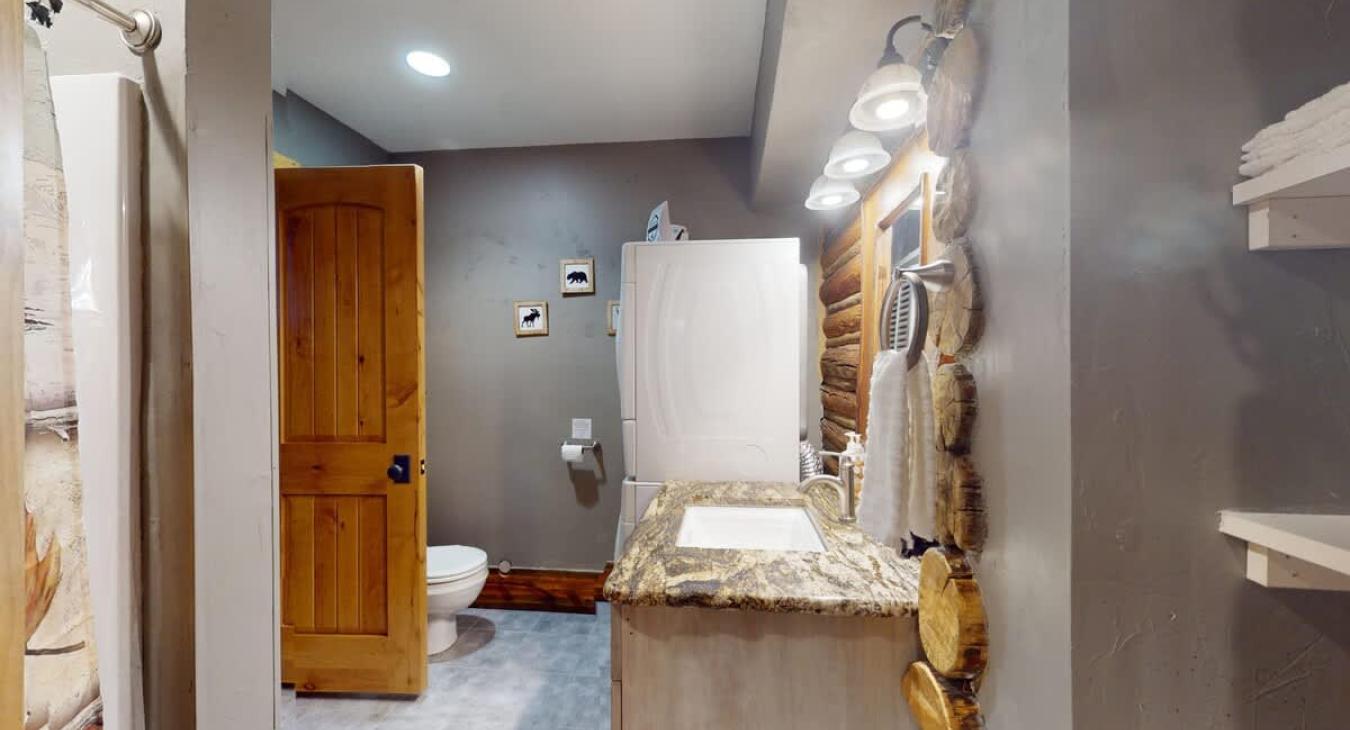 Bathroom #1 with standing shower, toilet, and sink vanity.