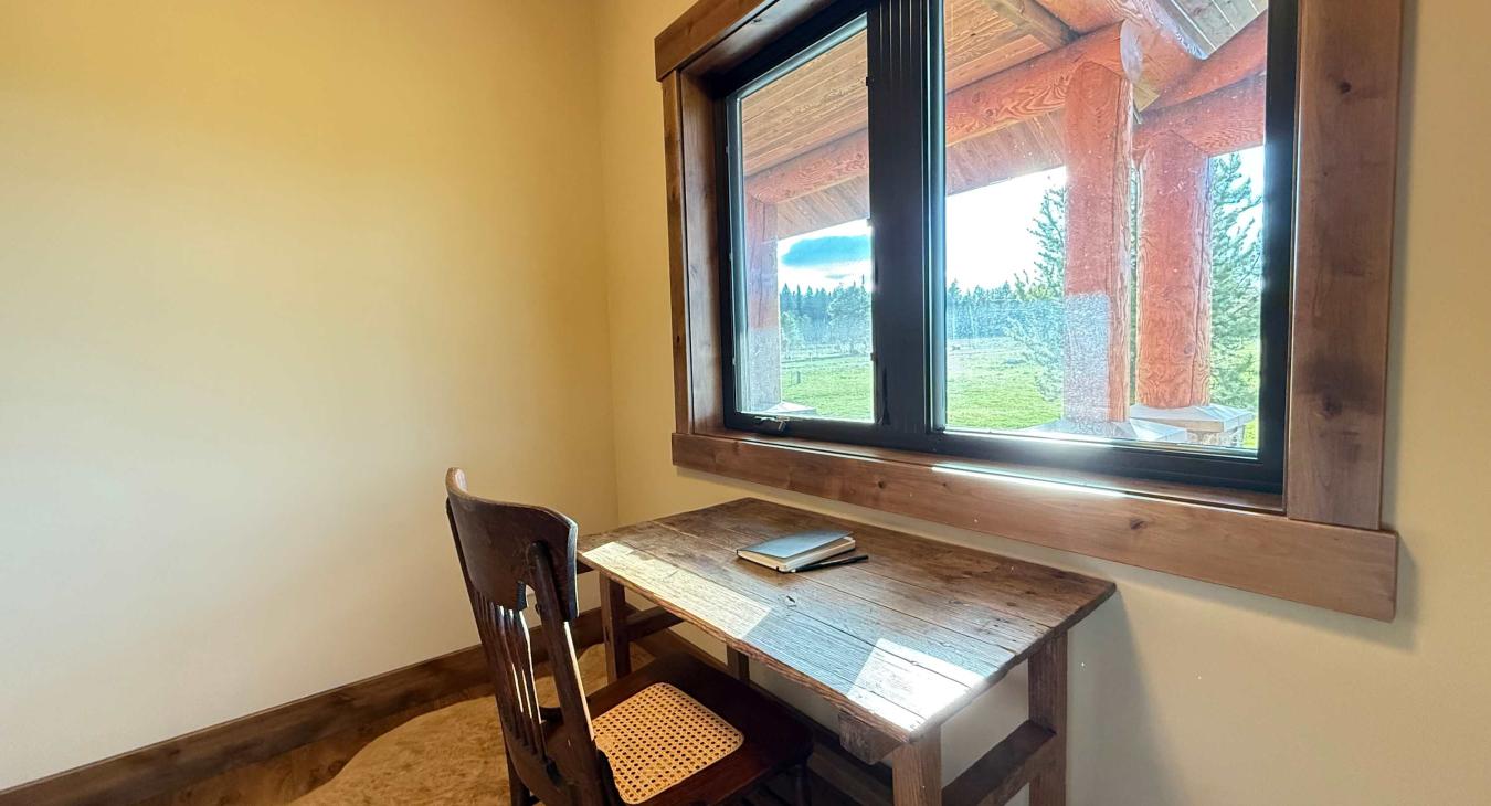 Small office with desk and beautiful window to look out of.