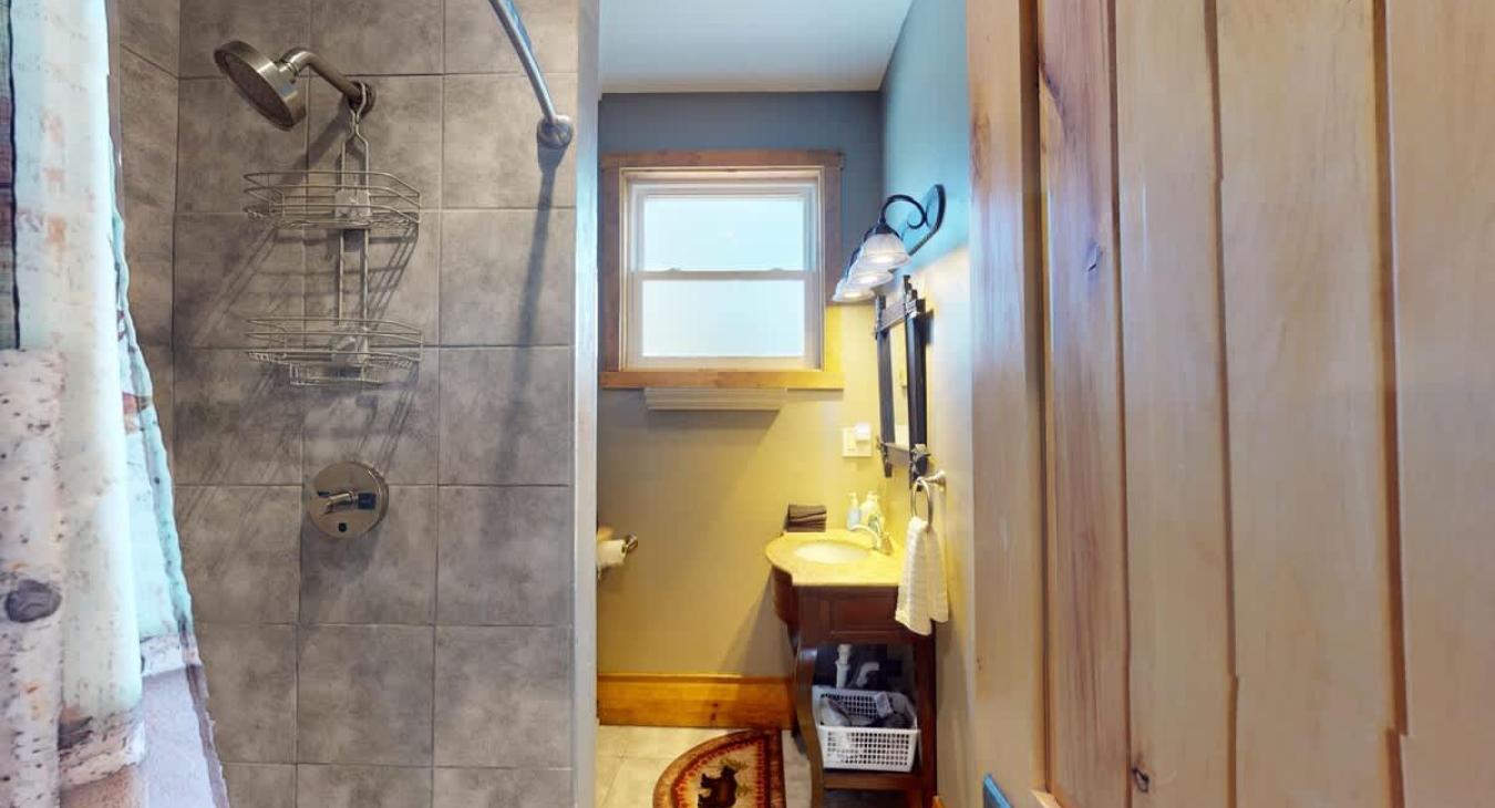 Shared bathroom upstairs with shower, toilet, and sink.