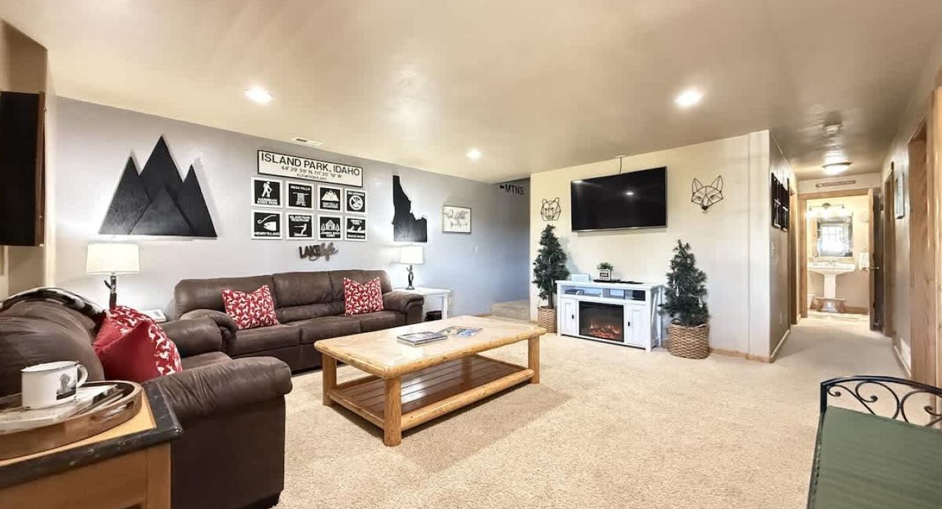 Upon entrance of the cabin you view the downstairs living room. Equipped with a smart tv and seating to relax during your stay.