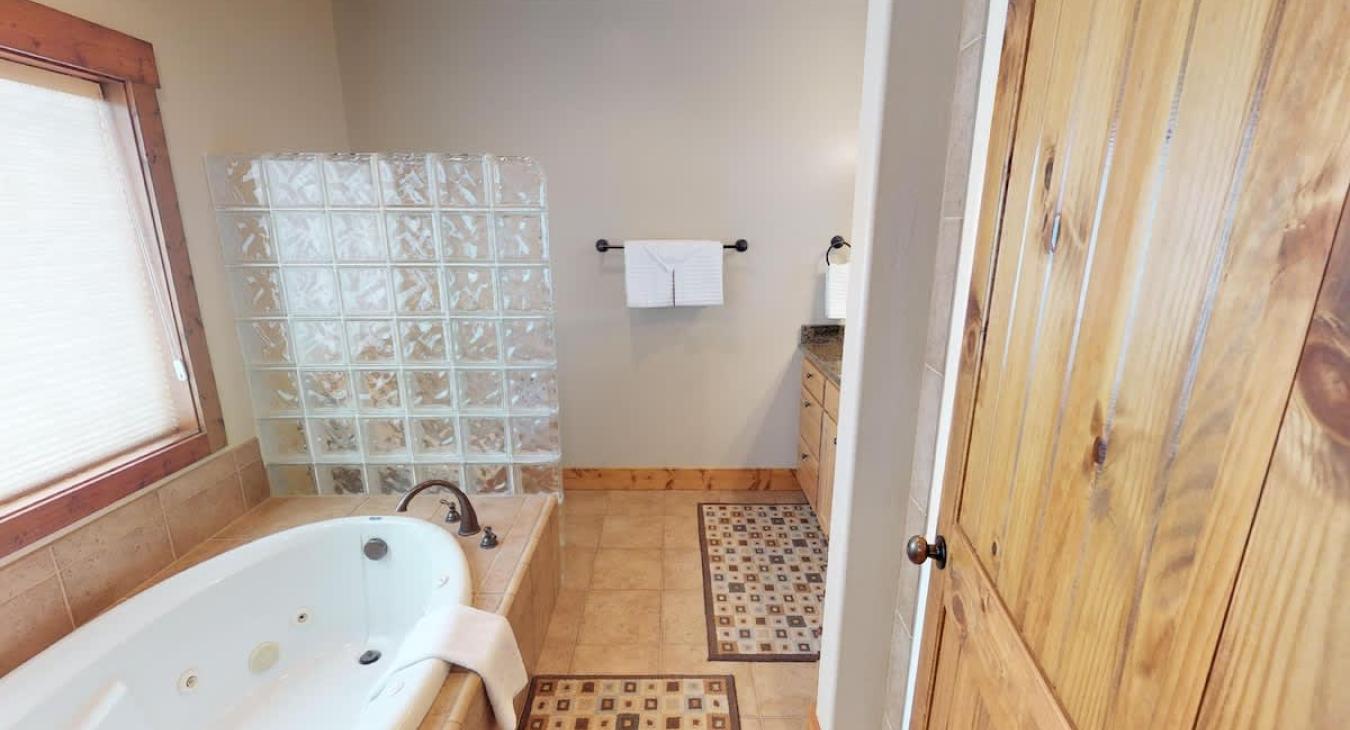 Located within the master bedroom is the ensuite bathroom with a standing shower, soaking tub, toilet, and mirror vanity.