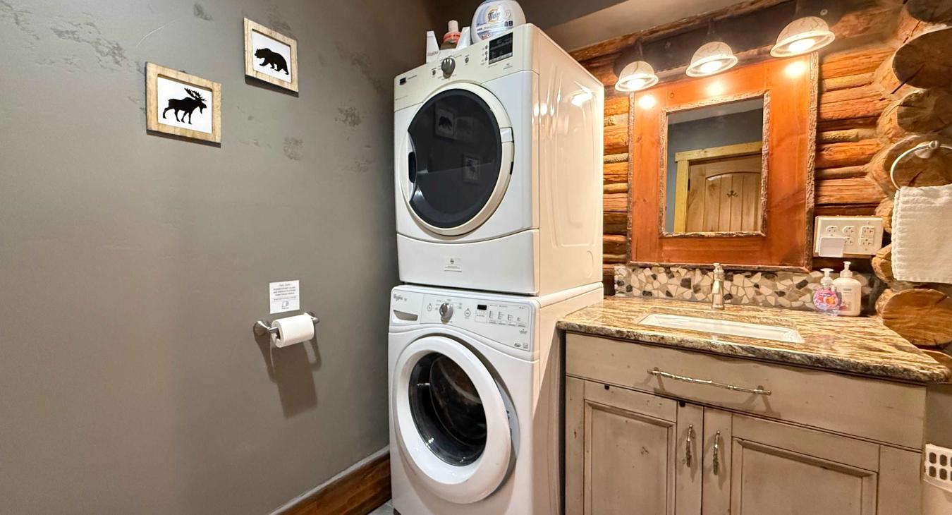 Features a convenient full-size stacked washer and dryer, combining laundry necessity with rustic cabin charm.
