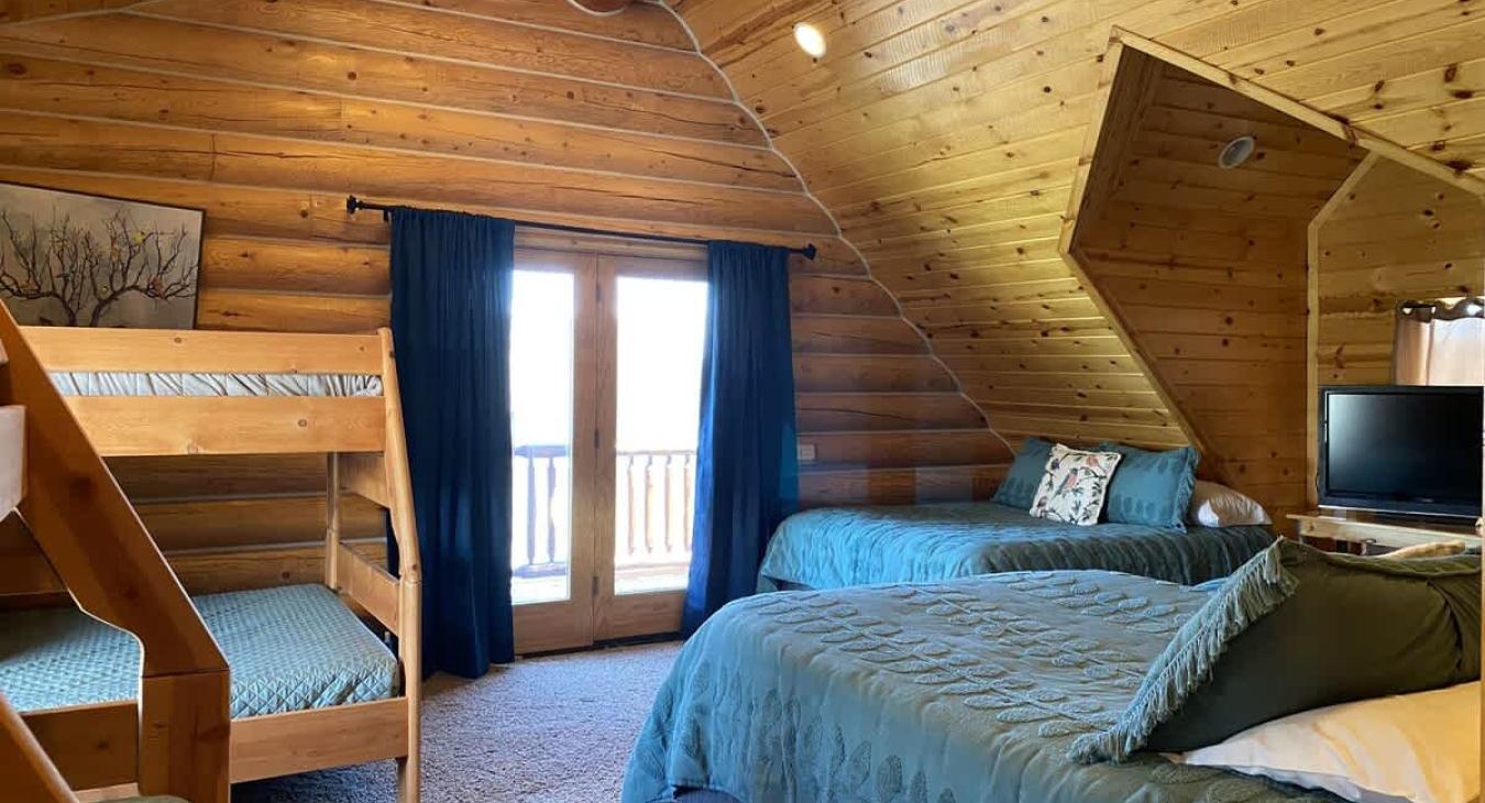 The ample number of beds—three queens, two twins, and two fulls—ensures that there’s plenty of space for everyone, whether for a family, a group of friends, or extended guests. Despite the large number of beds, the room remains inviting and cozy.