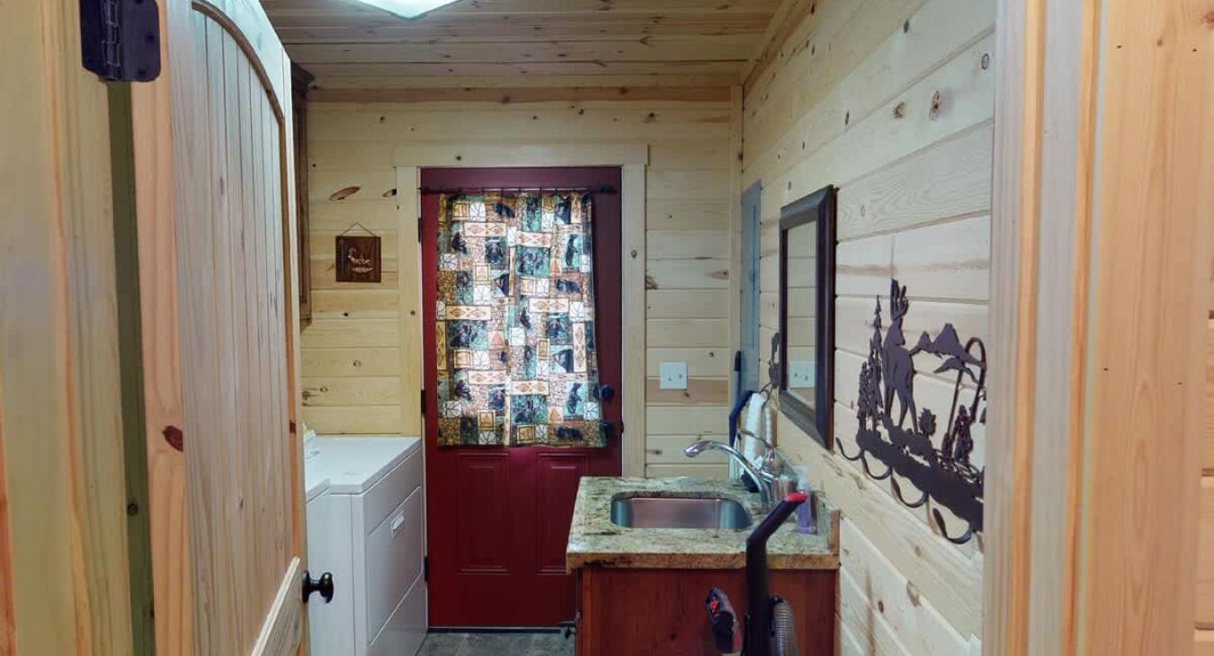 Mud room with laundry, toilet, and sink.