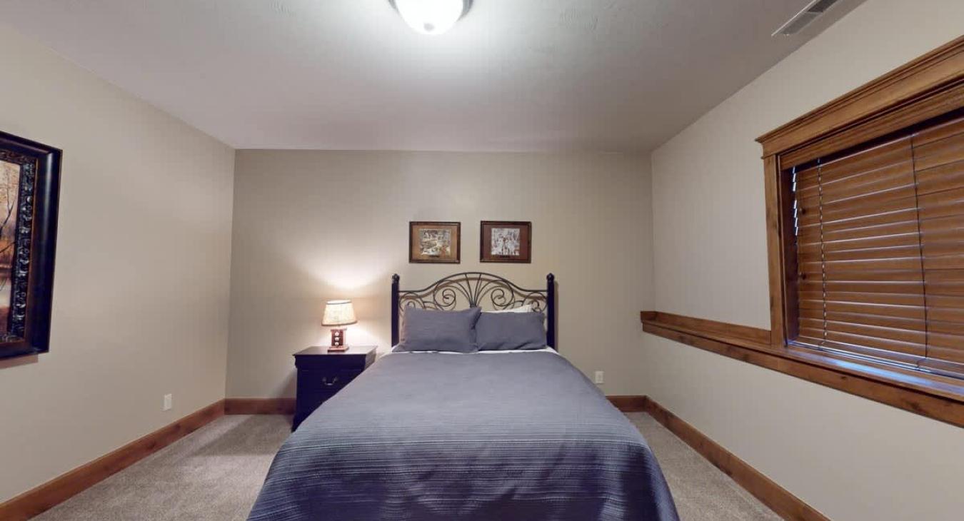 Bedroom #5 located in the basement with a Queen size bed.