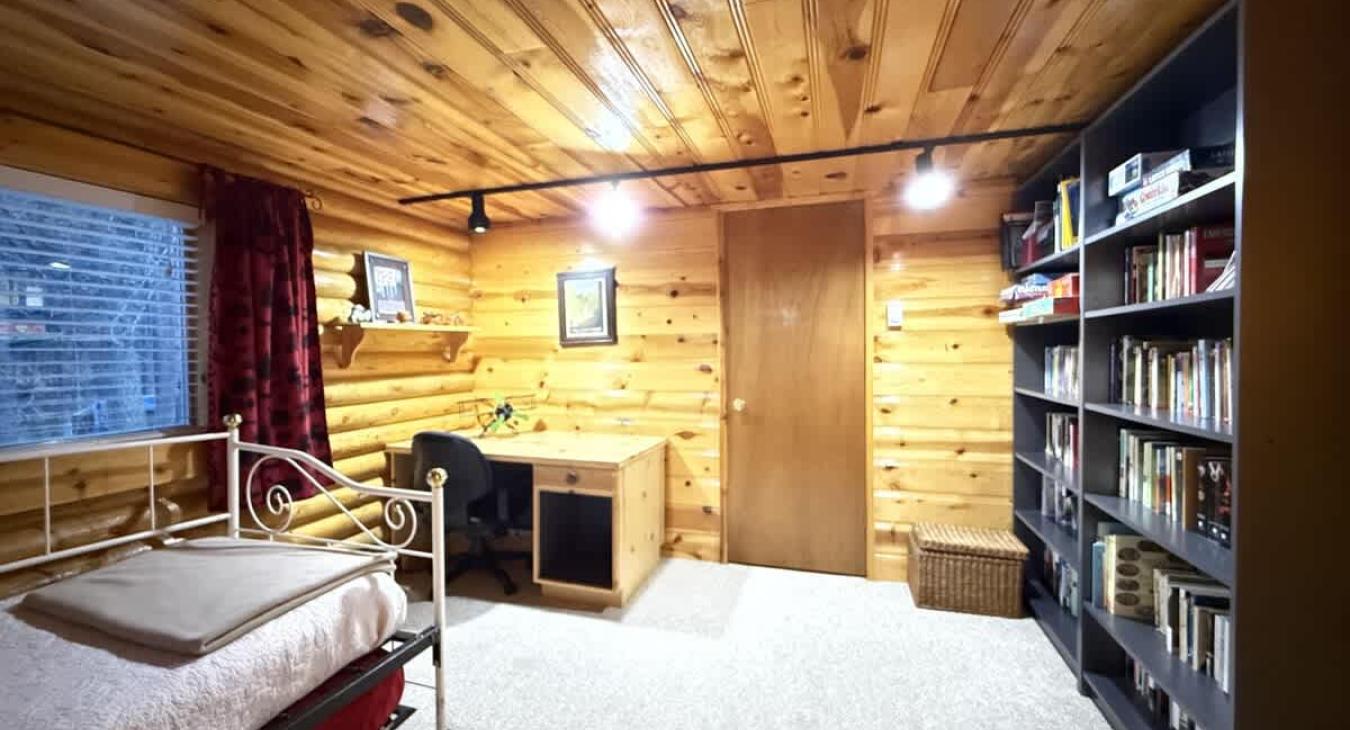 Second bedroom with desk and shelves with books and games to enjoy.
