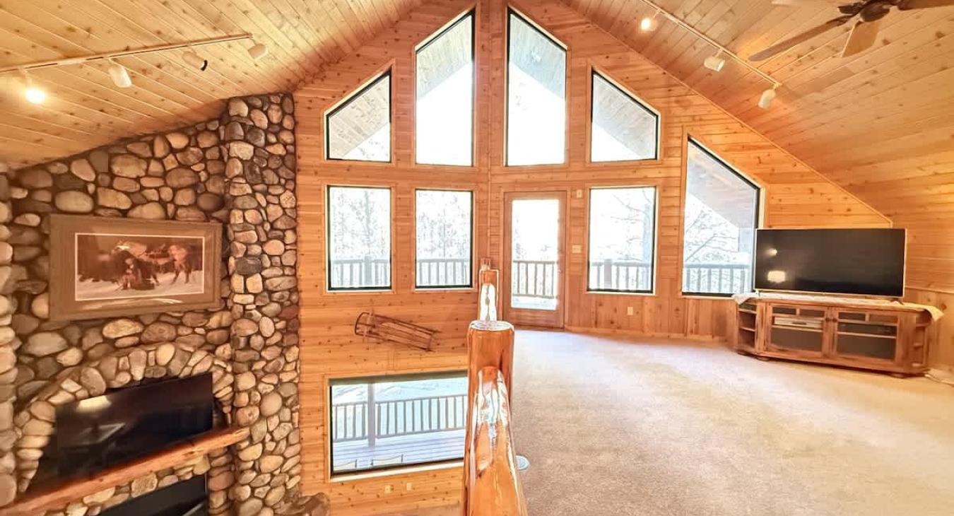 Upstairs loft with tv and seating. Large windows to enjoy the beautiful scenery.