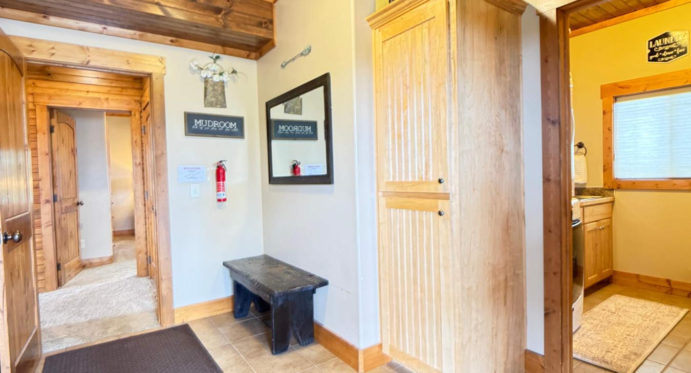 A functional main-floor mudroom at the entrance, offering a bench and storage wardrobe to neatly tuck away shoes and coats.