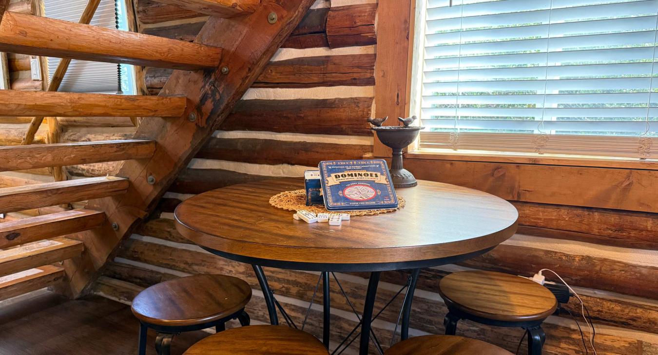 Tucked under the log stairs is a wonderful wooden card table with stools—ideal for playing board games or enjoying a morning puzzle.