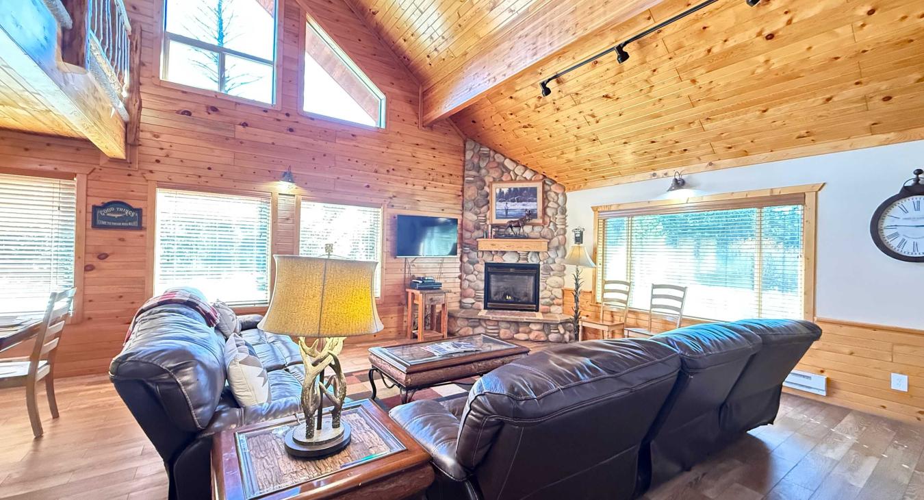 Large open living room with seating, television, and fireplace.