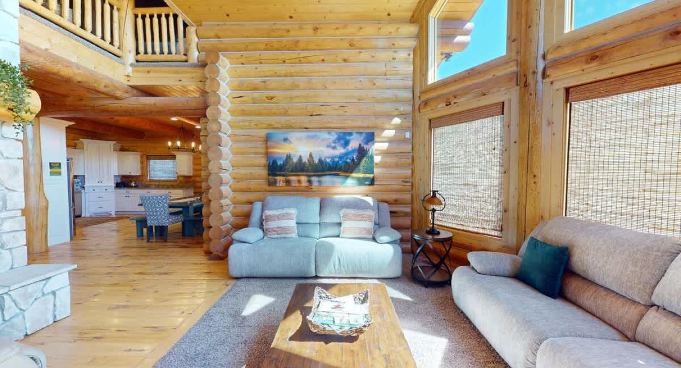 The seating area is inviting, with  large comfortable sectional sofas. This living room is the perfect balance of cozy and spacious, a welcoming spot to gather with family or unwind by the fire while taking in the views of the natural world outside.