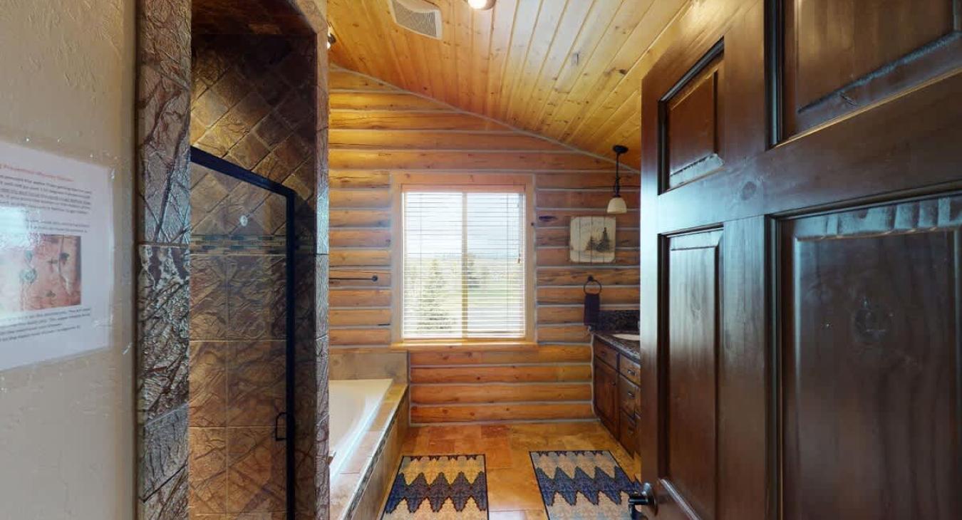 Upstairs shared bathroom on the West Wing with a soaking tub, standing shower, toilet, and sink vanity.