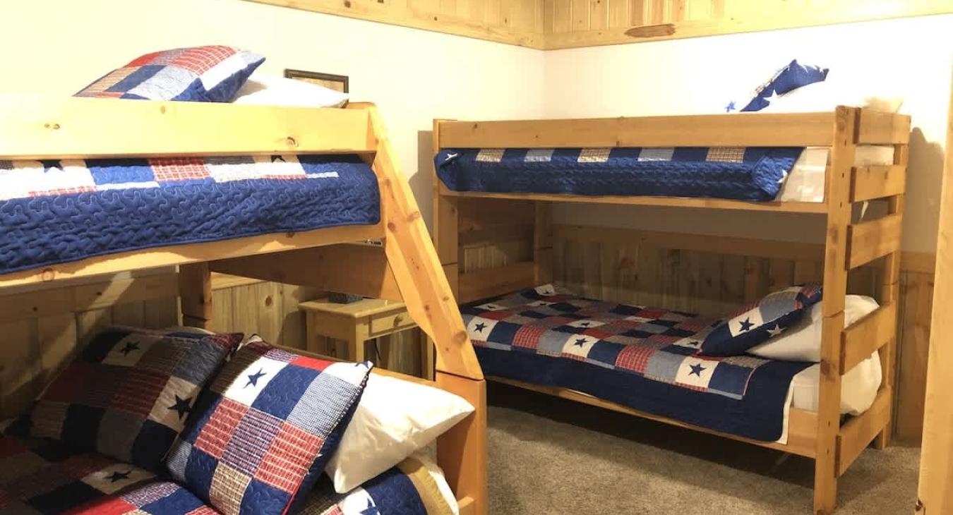 Bedroom #7 located downstairs with 3 twin beds and 1 double bed.