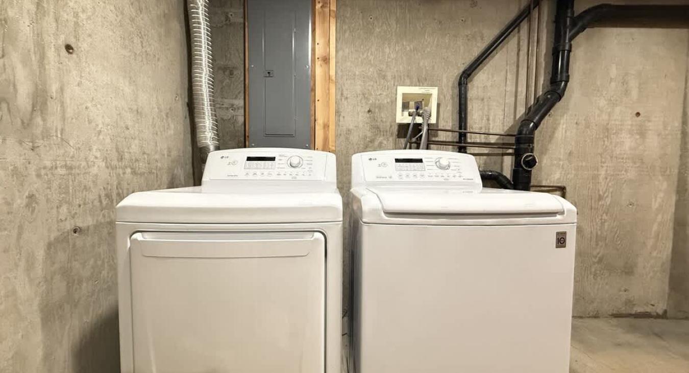 Washer and dryer located downstairs, laundry soap is provided.