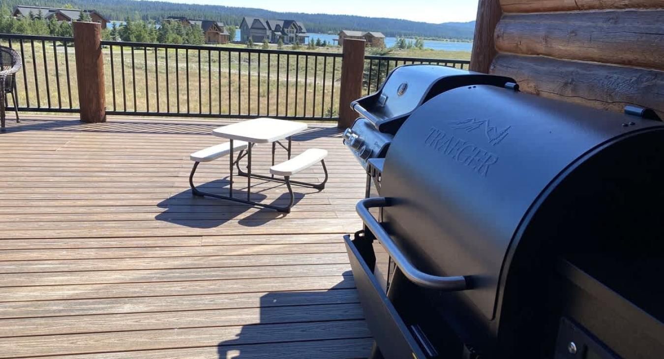 The outdoor deck serves as an inviting and functional extension of the cabin’s living space, offering a perfect setting for outdoor cooking, dining, and relaxation.