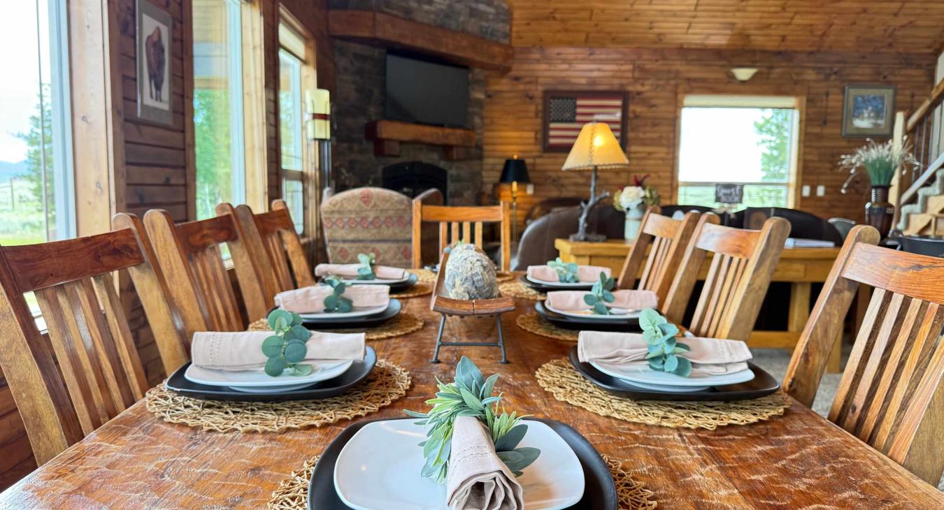 The dining room has a large table with seating and additional seating at the bar of the Island in the kitchen.
