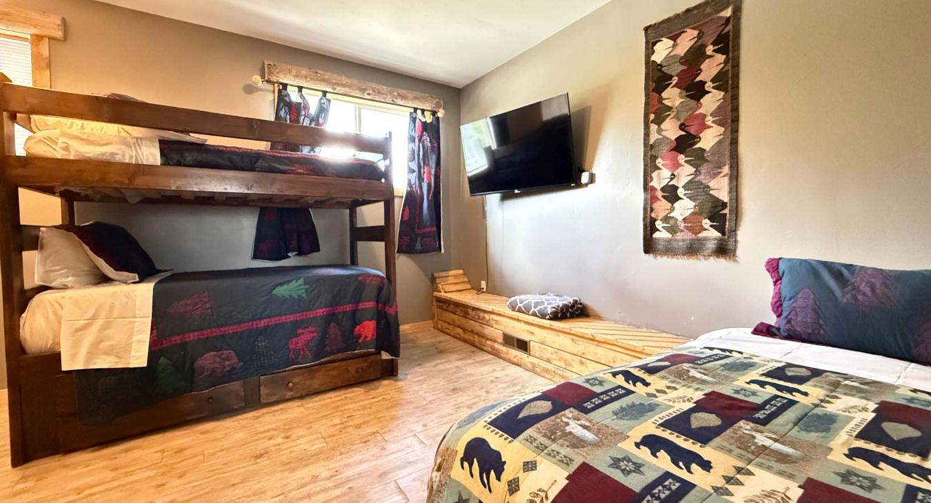 The ultimate kids' retreat comes complete with a large wall-mounted Smart TV and a long wooden bench setup for comfortable viewing.