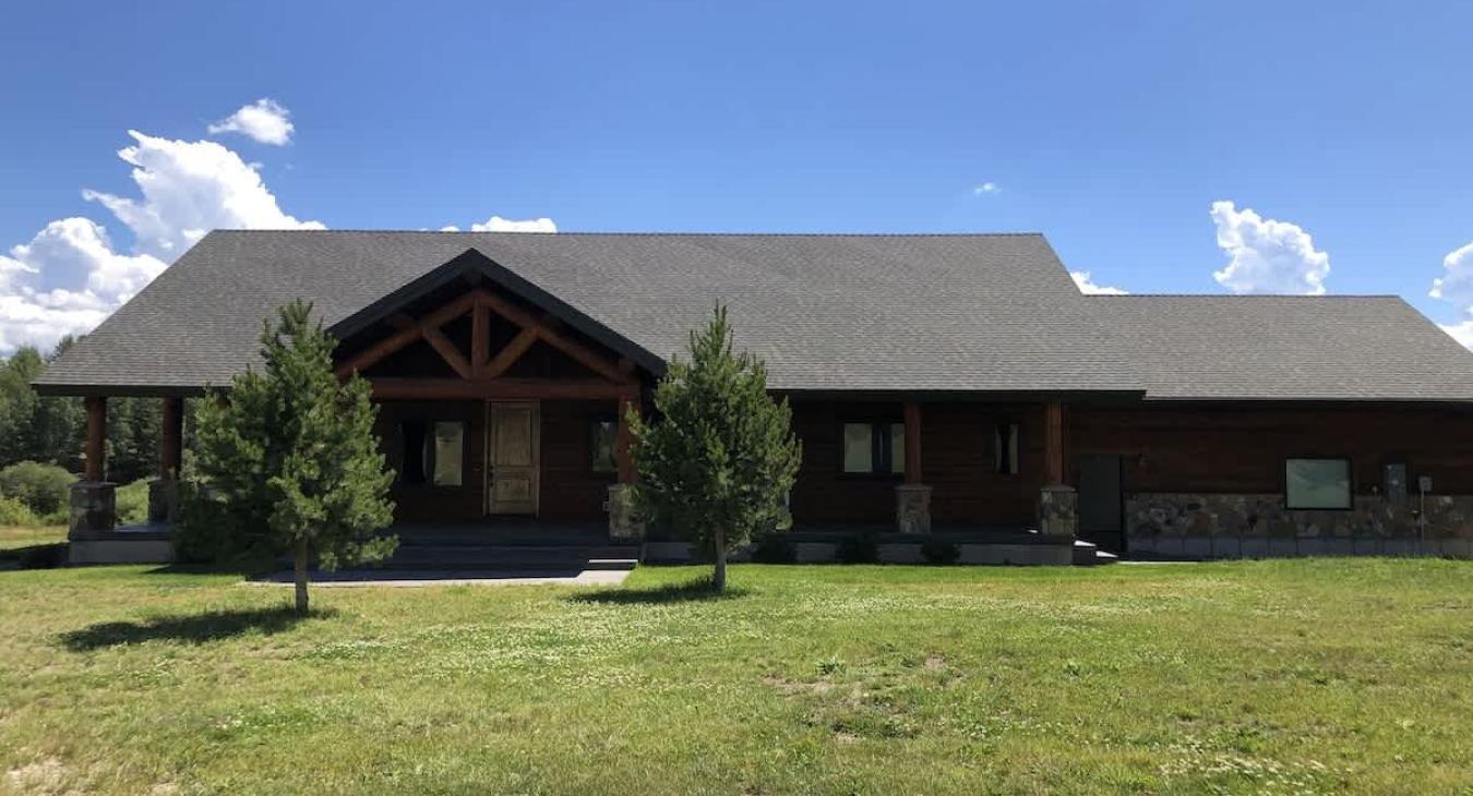 Lots of open grass surrounding the cabin.
