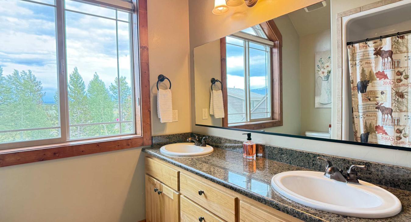 The spacious upstairs bathroom boasts a double sink vanity with granite countertops, offering plenty of space for everyone to get ready.