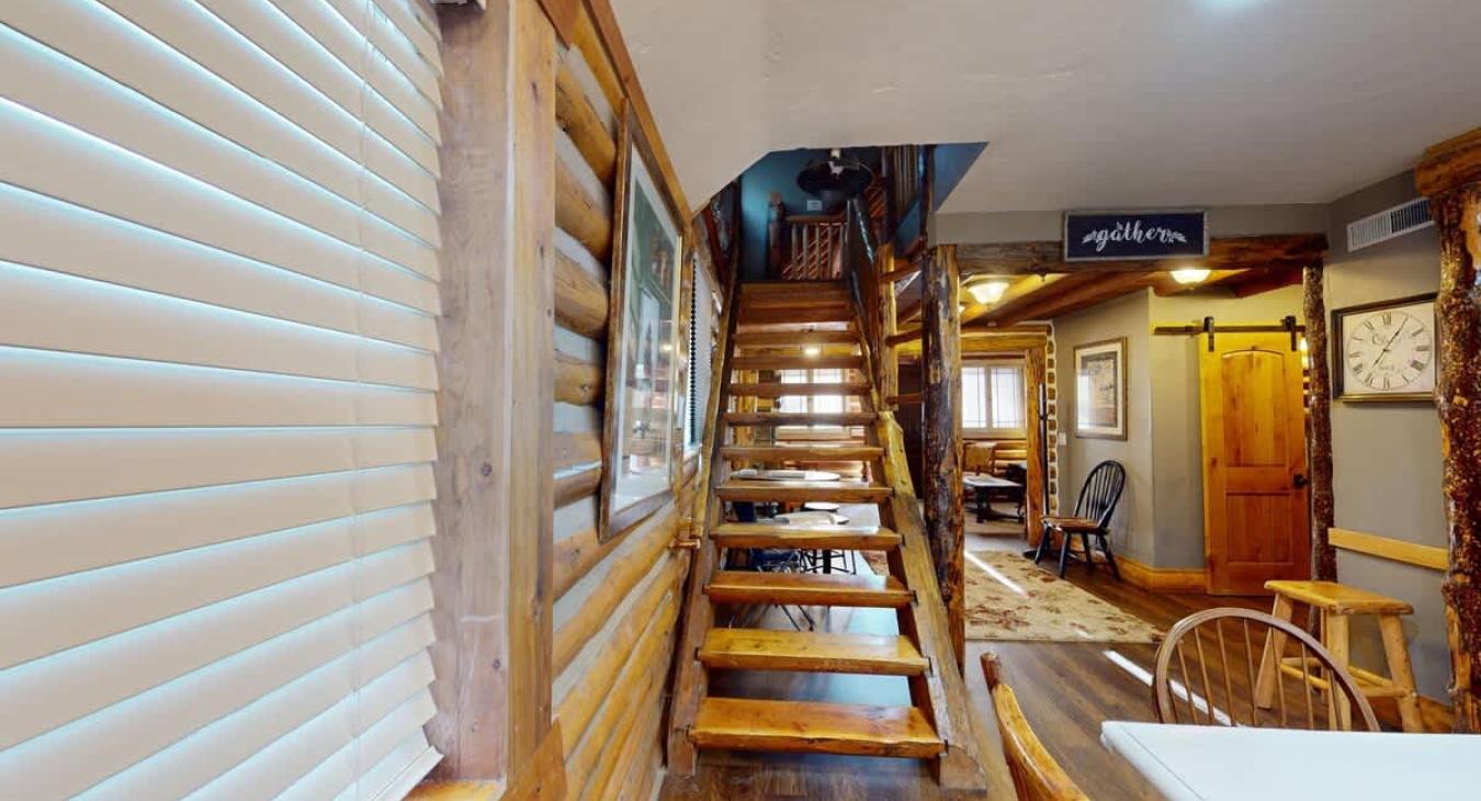 Adjacent to the dining table is the stairs to access the upper level.