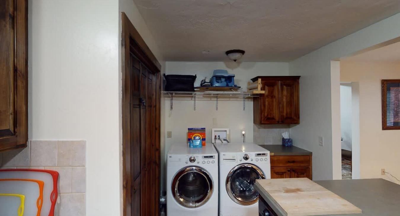A full size washer and dryer is located next to the kitchen with laundry soap provided.