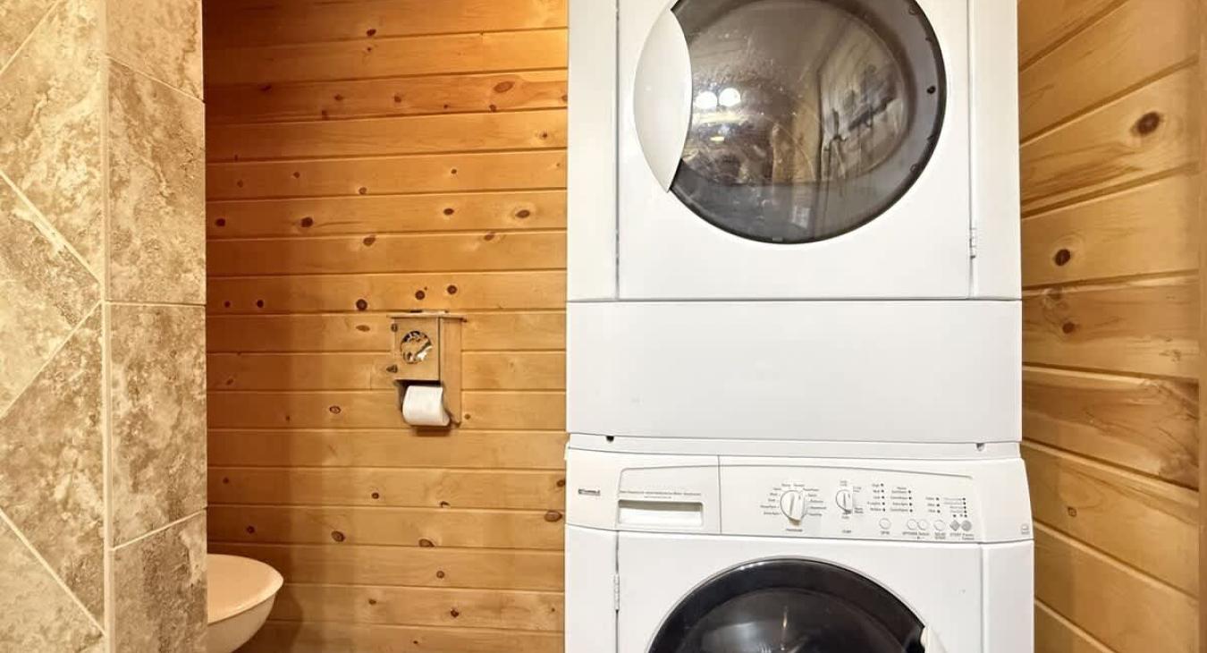 Stackable washer and dryer in the bathroom, laundry soap is provided.
