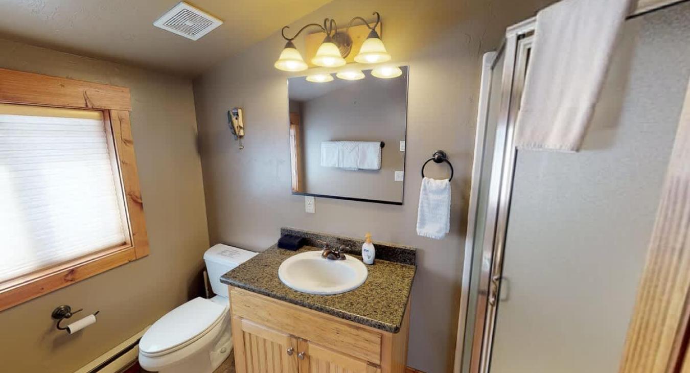 Located above the garage is a half bath with a toilet, sink vanity, and a standing shower.
