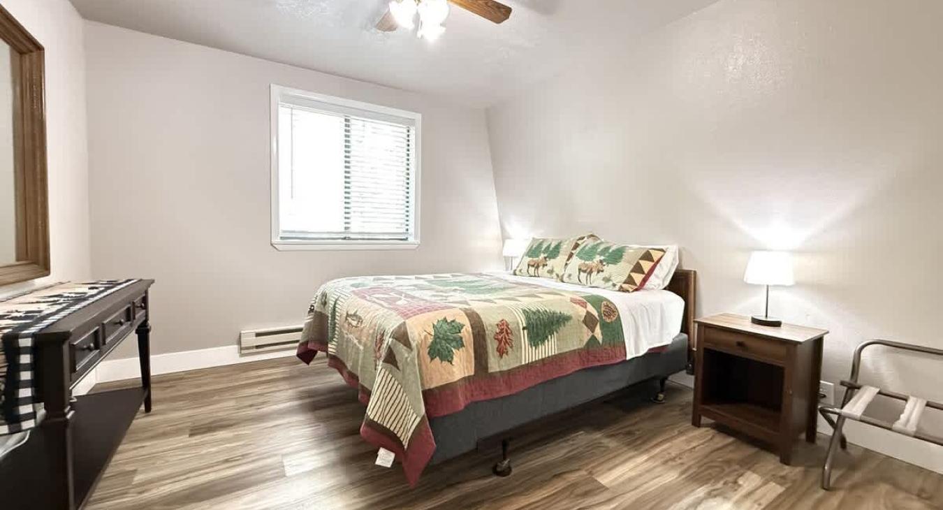 This bedroom features 1 queen bed and bedside tables. There are luggage racks for your suitcases.