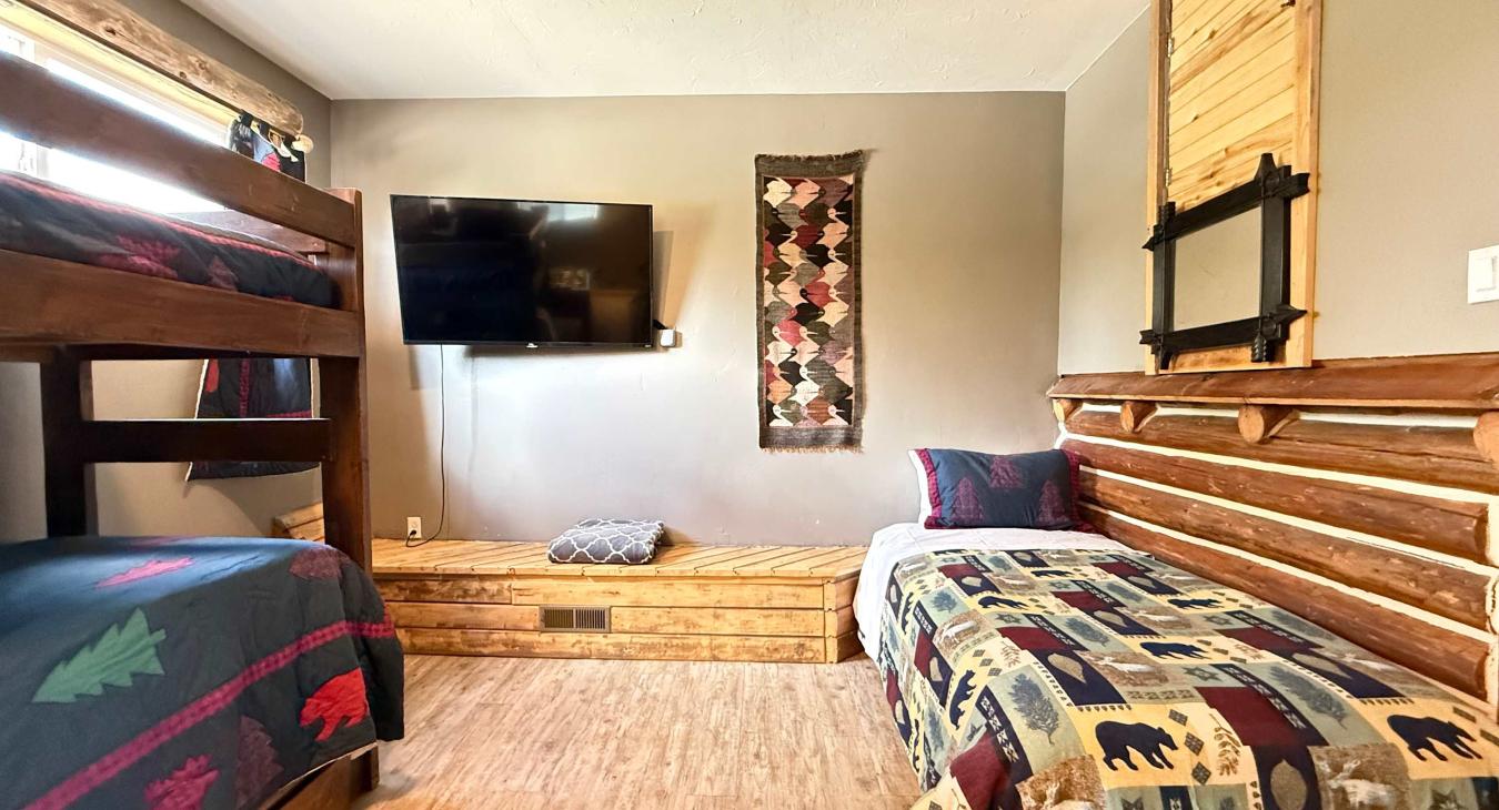 Perfect for kids and families, this spacious room features a sturdy wooden twin-over-twin bunk bed and a separate single bed.