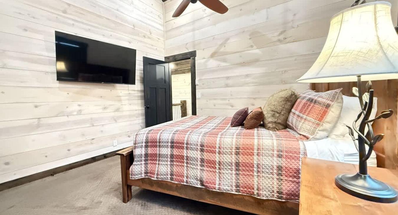 Queen bedroom with flat screen tv and walk in closet.