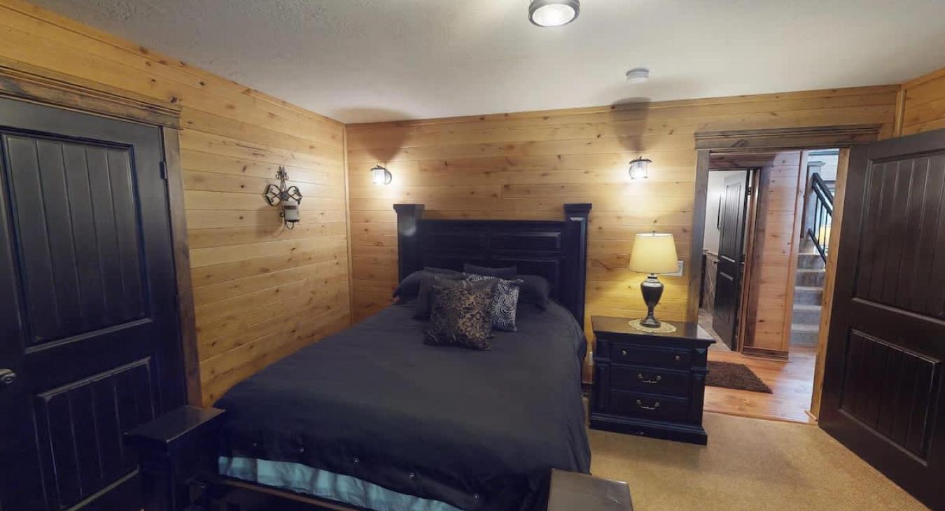 Bedroom #5 on the main level with a Queen size bed. Storage is provided in the closet for your belongings during your stay.