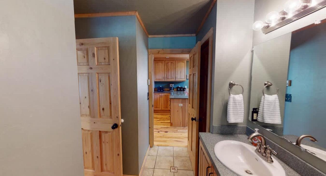 Shared downstairs bathroom with shower tub combo, toilet, and sink vanity.